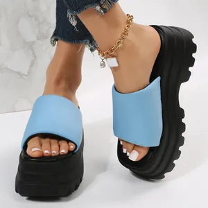 Detail of light blue platform slides with a thick black sole and square toe design