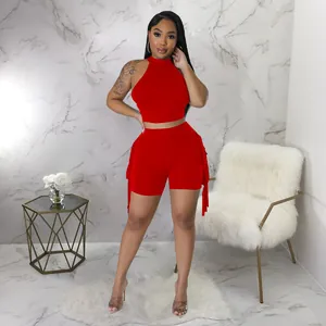 Detail view of a vibrant red sleeveless two-piece outfit with fringe trim shorts.