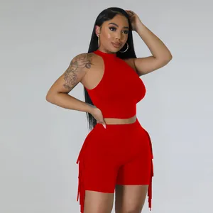 Detail shot of a vibrant red sleeveless crop top and fringe shorts two-piece set