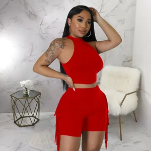Detail view of a vibrant red sleeveless crop top and matching fringe shorts set.