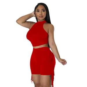 Detail view of red two-piece set with sleeveless crop top and fringe shorts.