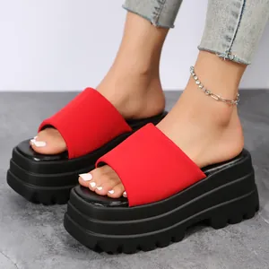 Detailed shot of trendy red platform slides featuring thick black serrated soles