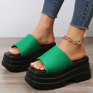 Stylish green platform slide sandals featuring thick black chunky sole and modern square toe