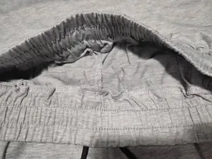 Close-up detail of grey elastic waistband with drawstring on cotton shorts