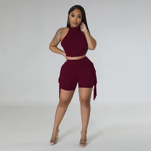 Detail view of women's maroon two-piece set featuring fringe shorts and halter top.