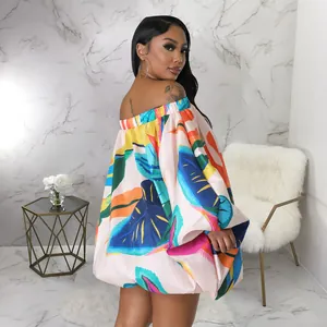 Vista trasera de un minivestido veraniego con estampado tropical y hombros caídos