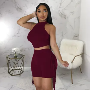 Close-up of wine red two-piece set with sleeveless halter top and fringe shorts.