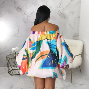 Vista posterior de un vestido con estampado tropical, hombros descubiertos y mangas murciélago.