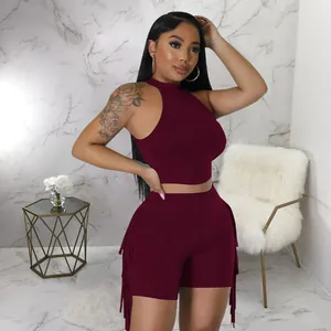 Close-up of burgundy two-piece set featuring sleeveless crop top and fringe detail shorts.