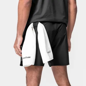 Close-up back view of men's black sports shorts with towel loop and white towel
