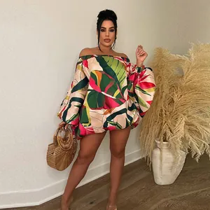 Detalle de minivestido con hombros descubiertos, estampado tropical y mangas murciélago