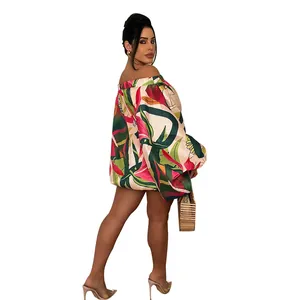 Vista detallada del vibrante estampado floral tropical en un minivestido con hombros caídos