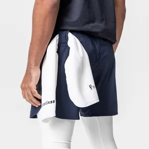 Close-up view of navy blue men's athletic shorts featuring a towel loop and white leggings