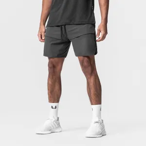 Close-up of men's dark grey athletic shorts with secure zipper pockets and drawstring.