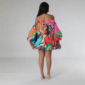 Vista trasera de un minivestido con estampado botánico, hombros descubiertos y mangas murciélago.