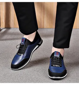 Detailed view of men's navy blue hollow breathable casual leather shoes on feet.