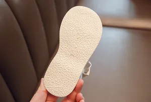 Detail of anti-slip textured sole on children's sandals showing size 23 and soft material