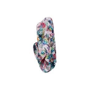 Vista lateral de vestido corto con estampado floral tropical y hombros descubiertos de murciélago