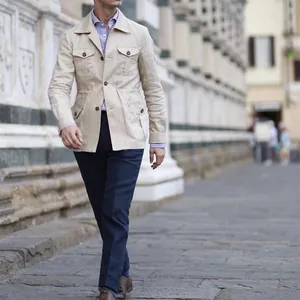 Man wearing a beige linen multi-pocket safari jacket in a classic British vintage style.