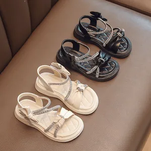 Girls' summer sandals with rhinestones and bow detail on soft anti-slip soles.
