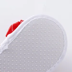 Close-up view of the non-slip soft sole texture on white baby bow sandals for infants