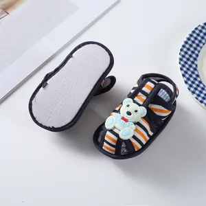 Close-up of soft sole baby sandals with striped pattern and cute bear decor