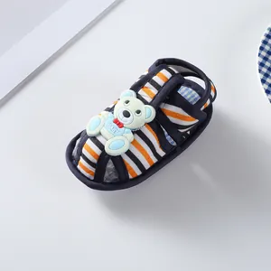 Close-up view of soft sole baby sandals featuring a striped pattern and cute bear detail