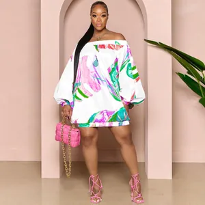 Primer plano de vestido corto con hombros descubiertos y estampado de hojas tropicales