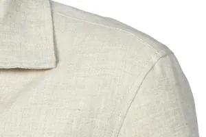 Macro view of breathable beige linen fabric and shoulder stitching on men's jacket