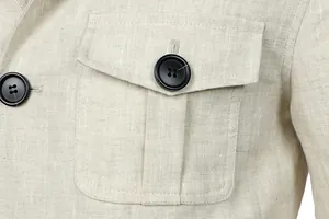 Macro detail showing premium linen fabric texture and black button on beige utility jacket.