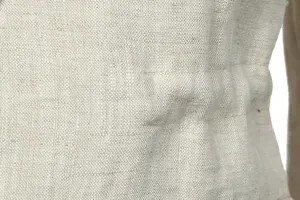 Macro view of natural beige linen fabric texture on a vintage men's work jacket