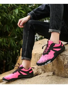 Close-up of pink breathable hiking shoes for couples in a rocky outdoor setting.
