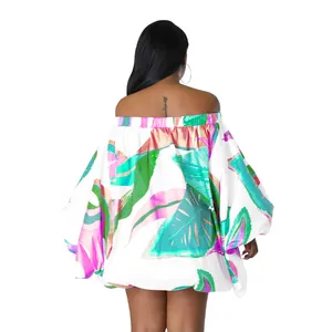 Vista trasera de un minivestido de flores con estampado de hojas tropicales y mangas murciélago.