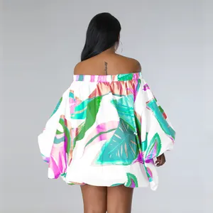 Vista trasera de vestido mini con hombros descubiertos, estampado tropical y mangas murciélago