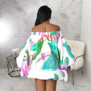 Vista trasera de mini vestido con hombros descubiertos, estampado tropical y mangas murciélago