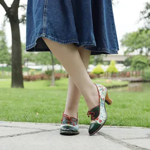 Detailed macro view of retro pastoral style high-heeled shoes with floral patchwork