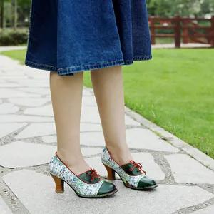 Detailed side view of floral spliced vintage pastoral style high heel pumps on stone path