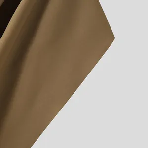 Λεπτομερές κοντινό πλάνο που δείχνει τις ραφές και την υφή του υφάσματος μιας καφέ κάπας