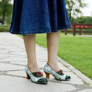Detail view of vintage floral patchwork high heel pumps being worn on a stone walkway.