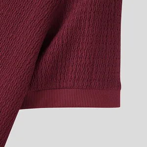 Gros plan du tricot texturé rouge bordeaux pour hommes avec détails de l'ourlet côtelé
