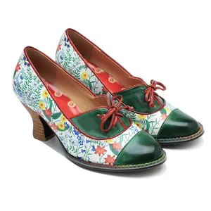 Close-up detail of floral patchwork vintage pastoral pumps with red bow decoration