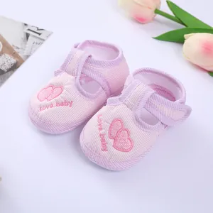 Detailed view of pink striped baby shoes featuring heart embroidery and soft soles