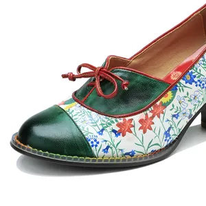 Macro detail of floral patchwork vintage high-heeled pumps featuring red leather bow tie
