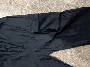 Vue détaillée d'un pantalon cargo noir avec une grande poche latérale et taille à cordon