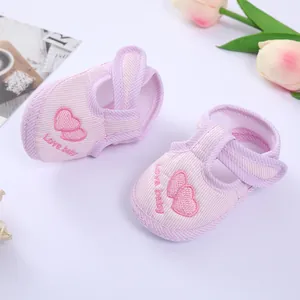 Detailed view of pink striped baby pre-walker shoes with heart embroidery