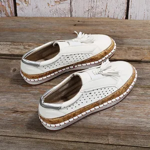 Mocassins blancs avec glands et semelle plateforme texturée style liège élégants.