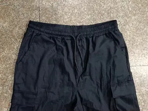Vue détaillée du pantalon cargo noir pour hommes avec une taille à cordon de serrage
