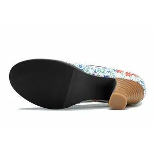 Detailed view of non-slip black sole and wood grain chunky heel on floral pumps