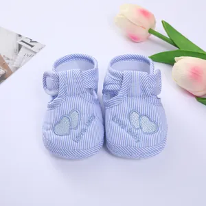 Detail of soft-sole baby pre-walker shoes with blue stripes and heart embroidery