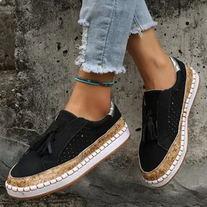 Détail de mocassins noirs à enfiler avec glands et semelles plateforme en liège